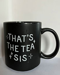 a black mug from the front with the quote 'That's the tea sis'
